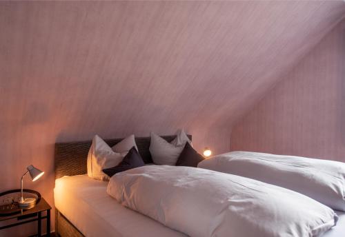 a bedroom with two beds with white sheets and pillows at Hotel Schatulle in Laufersweiler