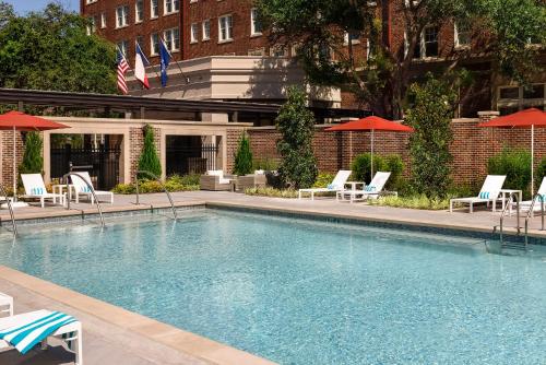 una grande piscina con sedie e ombrelloni di Warwick Melrose Hotel a Dallas