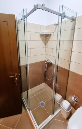 a shower with a glass door in a bathroom at Master Hotel in Berat