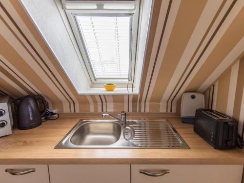a kitchen with a sink and a window at Ferienwohnung am Starenkasten in Berumbur