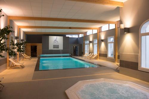 a large pool in a building with a swimming pool at Hotel Regina & Spa in Berck-sur-Mer