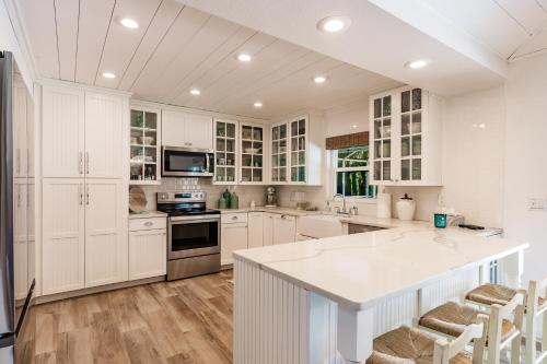 a kitchen with white cabinets and a kitchen island at Siesta Key Island Rentals in Siesta Key