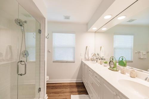 a white bathroom with a sink and a shower at Siesta Key Island Rentals in Siesta Key