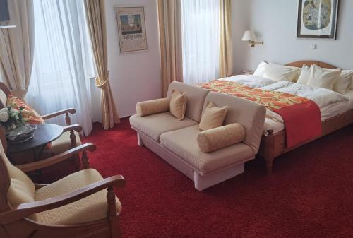 um quarto com uma cama, um sofá e uma cadeira em Haus Berlin em Kaub
