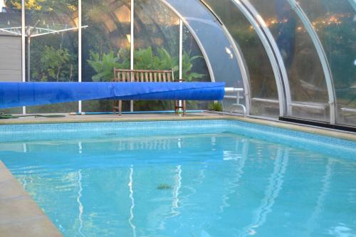 une piscine avec de l'eau bleue dans un immeuble dans l'établissement Clos Caritan, à Perdreauville