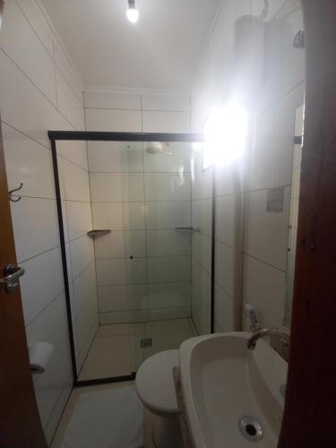 a bathroom with a shower and a toilet and a sink at Hotel Mandino in Alta Floresta