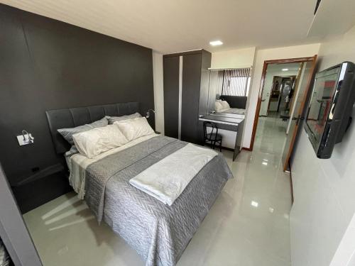 a bedroom with a bed and a desk in a room at INCRIVEL FLAT106 PASSARGADA VISTA p MAR in Vila Velha