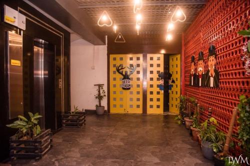 a hallway with yellow and red walls and potted plants at Hotel La Vista Inn in Tinsukia