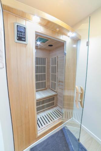 - un sauna avec une porte en verre dans la pièce dans l'établissement PRESTIGELOC - 3 Studios au Choix - 2 avec Sauna privé gratuit, 1 avec 3 Couchages, Centre-ville, à Orléans