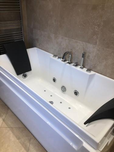 a bath tub with a sink and a book on it at Bank Quay, Caernarfon in Caernarfon