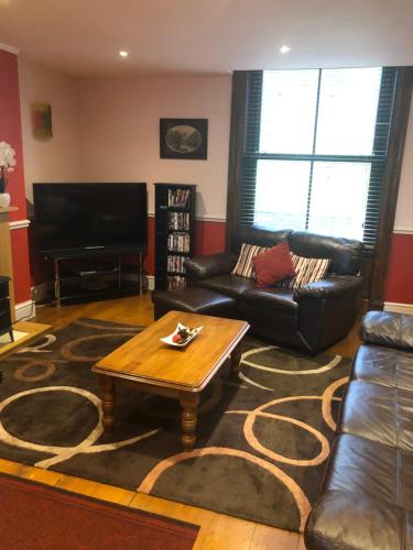 a living room with a couch and a coffee table at Bank Quay, Caernarfon in Caernarfon