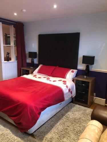a bedroom with a large bed with a red blanket at Bank Quay, Caernarfon in Caernarfon