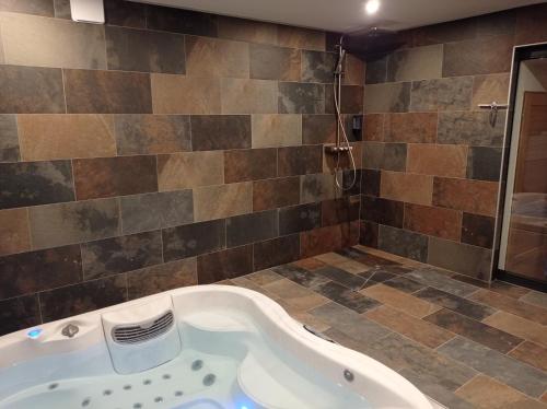 a bath tub in a bathroom with a shower at L'espaco in Saint-Jeure-dʼAy