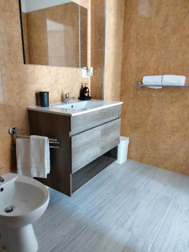 a bathroom with a sink and a toilet and a mirror at Oasi Le Fontanelle in Cerignola