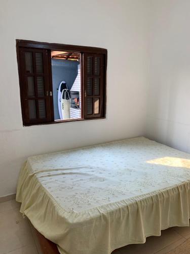 a bed in a room with a window at arco iris in Camburi