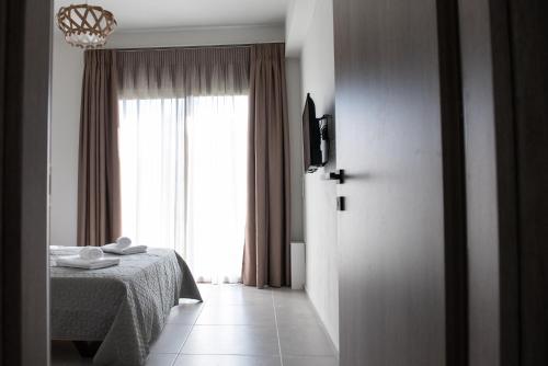 1 dormitorio con cama y ventana grande en LUXURY AUTONOMOUS GROUND FLOOR APARTMENT, en Igoumenitsa