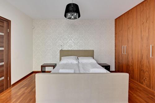 索波特的住宿－Grand Apartments - Willa Morska Premium，一间卧室配有一张大床和一个木制橱柜