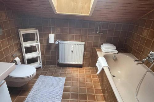 ein Badezimmer mit einer Badewanne, einem WC und einem Waschbecken in der Unterkunft Ferienwohnung im Herzen Allgäu in Altusried