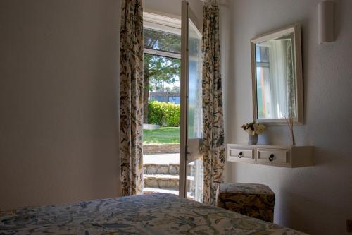 una camera da letto con una porta che conduce a un cortile di Ofir Beach House Bonança a Esposende