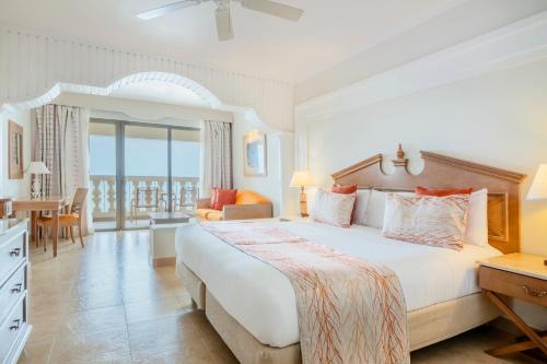 a hotel room with a large bed and a balcony at Iberostar Rose Hall Beach in Montego Bay