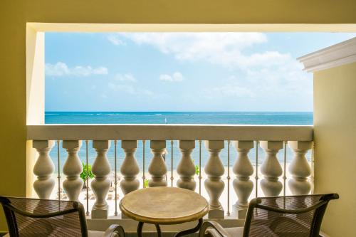 a balcony with a table and chairs and a view of the ocean at Iberostar Waves Rose Hall Beach - All Inclusive in Montego Bay