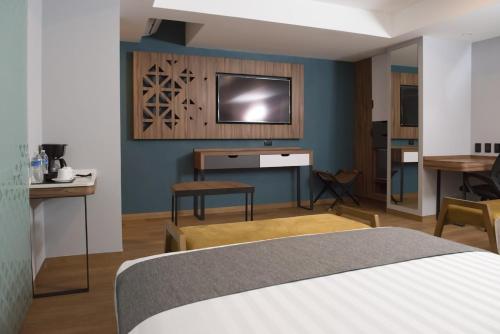 a bedroom with a bed and a tv on a wall at Hotel Flamencos Centro Histórico in Mexico City