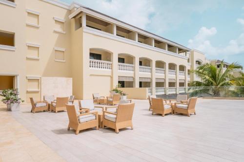 a patio with tables and chairs in front of a building at Iberostar Waves Rose Hall Beach - All Inclusive in Montego Bay