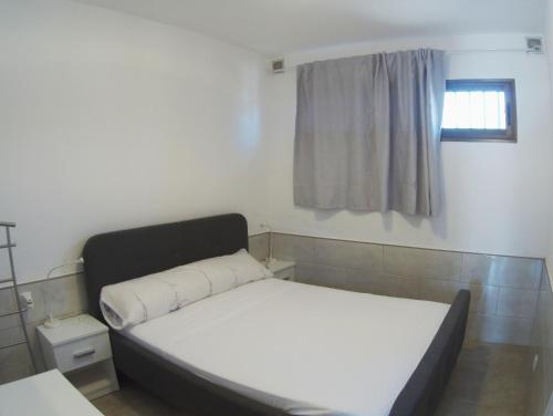 a small bedroom with a bed and a window at Alexa House in Costa de Antigua