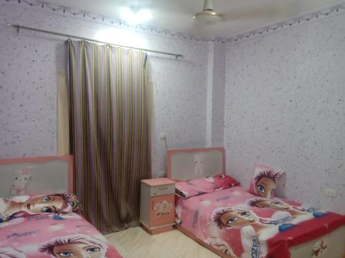 a bedroom with two beds with dolls on them at App12 - RAWDA - Enjoy the privacy of staying in a quiet apartment with free Wi-Fi as your complete second home in the heart of Hurghada in Hurghada