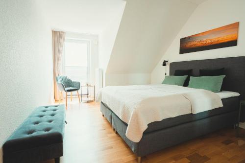 ホーヴァハトにあるFerienhaus-Ostseehusのベッドと椅子と窓のある寝室