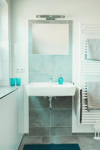 a bathroom with a white sink and a mirror at Ferienhaus-Ostseehus in Hohwacht