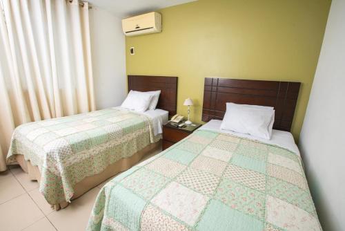 two beds in a hotel room with two beds sidx sidx sidx at Posada Blanca Hotel Boutique in Piura