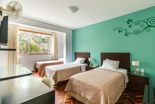 a hotel room with two beds and a window at Posada Blanca Hotel Boutique in Piura