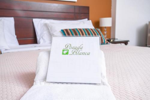 a white bed with a hotel blazer sign on it at Posada Blanca Hotel Boutique in Piura