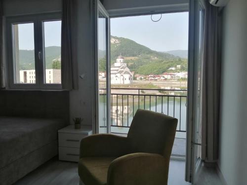 a living room with a chair and a large window at Vila Leolaz in Višegrad