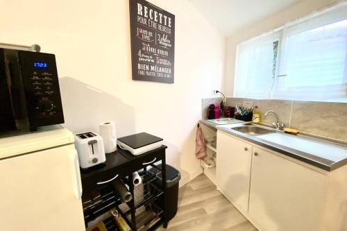 a small kitchen with a sink and a microwave at Chambre indépendante chez l'habitant in Nîmes