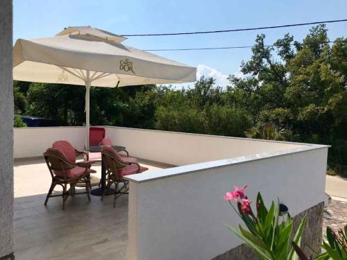un patio con una mesa y una sombrilla en Apartments in Klimno, Dobrinj - Insel Krk 41812, en Klimno