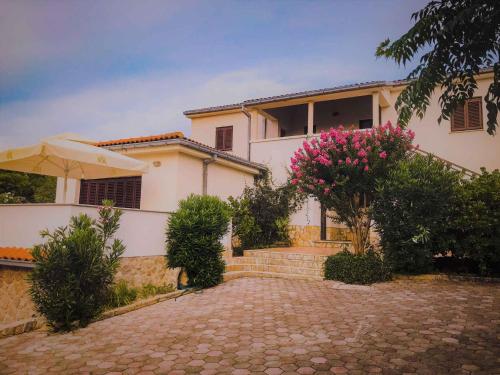 Una gran casa blanca con una entrada de ladrillo en Apartments in Klimno, Dobrinj - Insel Krk 41812, en Klimno