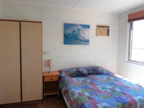 A bed or beds in a room at Pelican Point Waterfront Resort formerly Carnarvon Beach Retreat