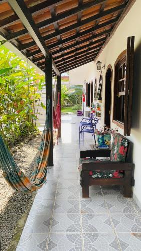 a hammock and a bench on a patio at Pousada Chalé Suíço in Paraty