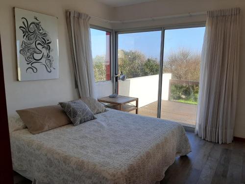 a bedroom with a bed and a large window at Delamar suites in La Paloma