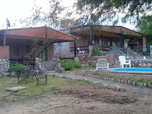 una casa con piscina y sillas en el patio en Las Morochas en Coronel Moldes