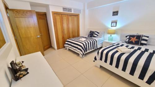 a room with two beds and a door in it at Las Olas by Destinos1a in Juan Dolio