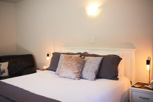 a bedroom with a white bed with pillows on it at Blenheim Palms Motel in Blenheim