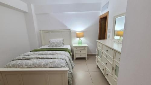 1 dormitorio con cama, tocador y espejo en Las Olas by Destinos1a, en Juan Dolio