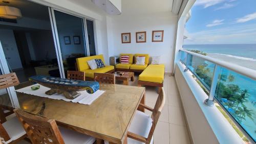 a balcony with a table and chairs and the ocean at Las Olas by Destinos1a in Juan Dolio