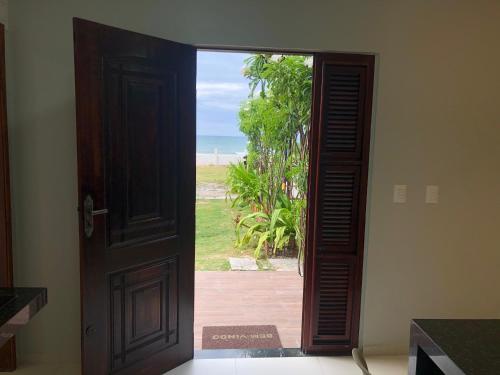 una puerta abierta con vistas a la playa en Studio pé na areia com 2 quartos sala cozinha en Trairi