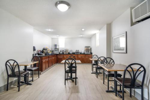 a dining room with tables and chairs and a kitchen at The Townhouse Inn in High Point