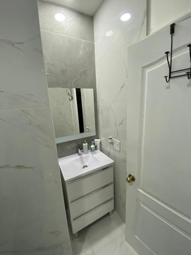 a white bathroom with a sink and a mirror at Casa Miami 1 in Miami