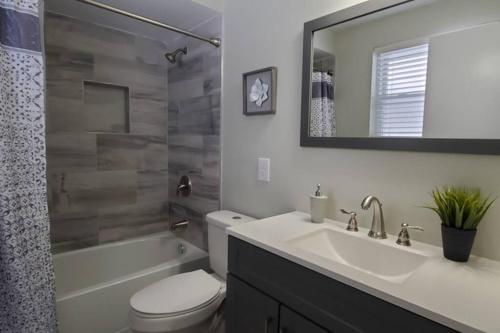 bagno con lavandino, servizi igienici e specchio di Cindy's Super Ranch Home a West Chester